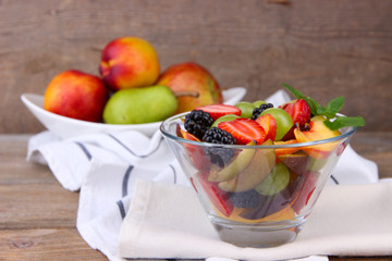 fresh tasty fruit salad on wooden table