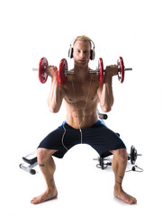 Obraz premium Man Wearing Headphones Lifting Weights in Studio