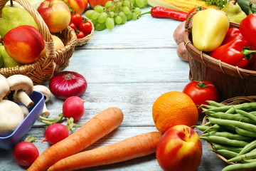 Fresh organic vegetables and fruits on wooden background