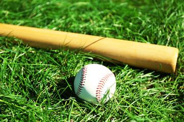 Obraz na płótnie Canvas Baseball bat, ball and glove on green grass background