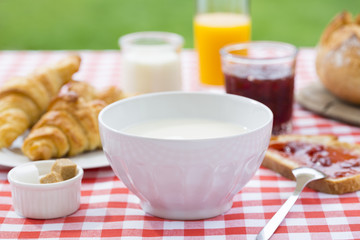 Breakfast with milk, orange juice, croissant, marmalade and brea