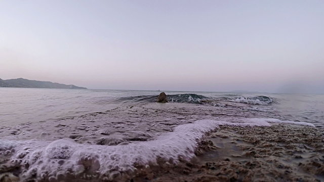 Calm sea waves lapping against flat rock