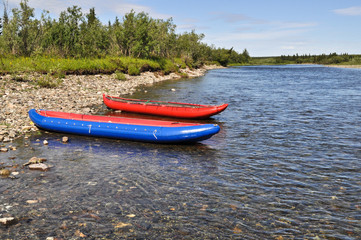 Two inflatable canoes on the shore of  North river.