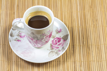 Porcelain coffee cup on bamboo background