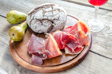 Slices of italian ham on the wooden board