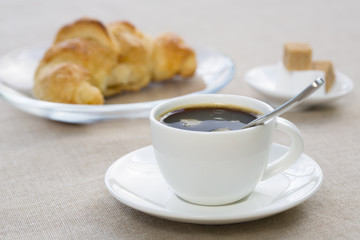 Breakfast with cup of black coffee and croissant