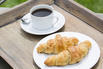 Breakfast with cup of black Coffee and Croissant
