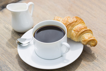 Breakfast with cup of black Coffee and Croissant