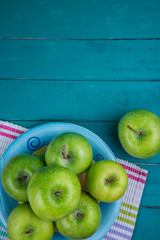 Farm fresh organic green apples on wooden retro blue table