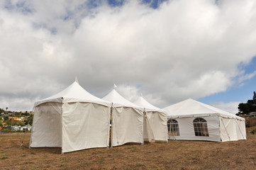 White tents in a dry field outdoors