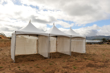 White tents in a dry field outdoors