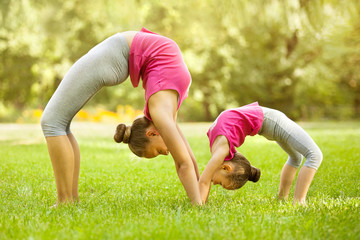 Mother and daughter doing exercise outdoors. Healthy lifestyle