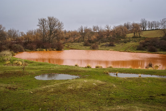 Unusual orange color of the water in the small lake, Pueblos roj