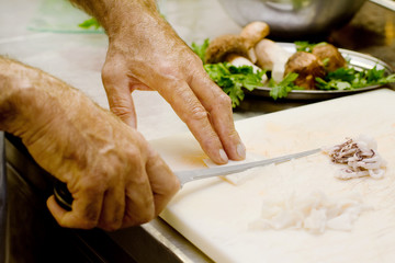 chef hands cutting small octopus
