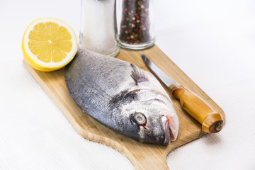 raw fish on a cutting board and knife