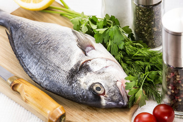 raw fish on a cutting board and knife