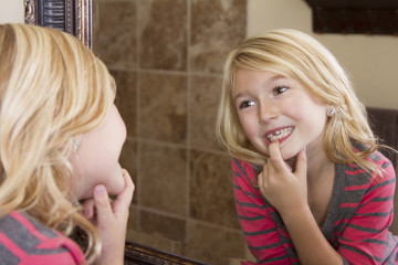 child looking in mirror at missing front tooth