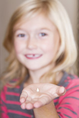 child holding her front tooth