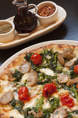 baked paesana pizza and condiment tray