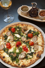 baked paesana pizza with a glass of wine