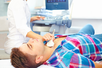 man undergoing the medical ultrasound examination - Powered by Adobe