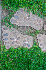 The path in the garden. Stone walkway on green grass