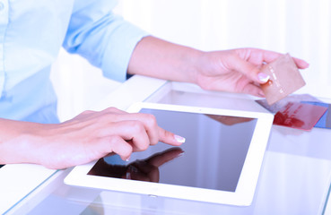 Woman using digital tablet and holding credit card in her hand,