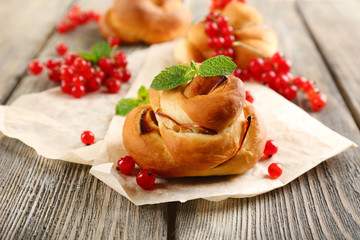 Tasty buns with berries on table close-up