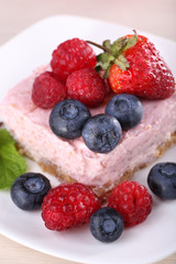Cake with fruits and berries on plate on wooden background