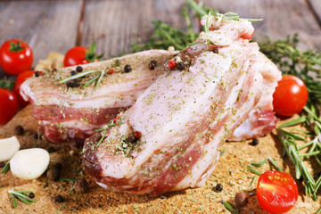 raw bacon with spices and tomatoes on wooden table