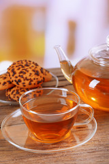 Teapot and cup of tea on table on light background