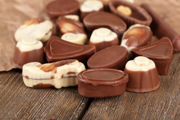 Different kinds of chocolates on wooden table close-up