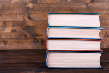 Books on wooden table on wooden wall background