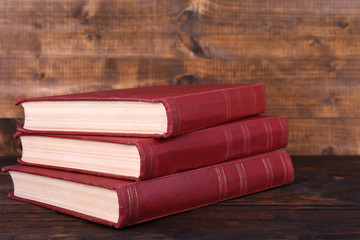 Books on wooden table on wooden wall background