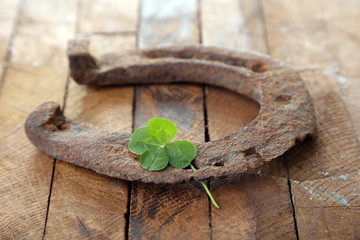 Naklejka na ściany i meble Old horse shoe,with clover leaf, on wooden background
