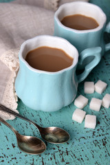 Fototapeta na wymiar Cups of coffee with sugar and napkin on wooden table
