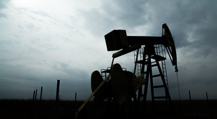 Naklejka premium Oil and gas well silhouette in remote rural area