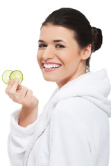 Beautiful woman receiving facial mask of cucumber