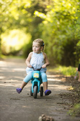 Junges Mädchen sitzt auf Spielzeug Fahrrad im Park