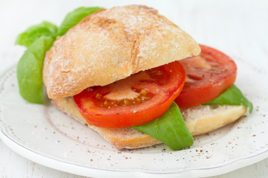 sandwich with tomato and basil on plate