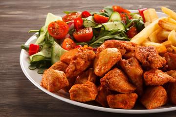 Fried chicken nuggets, French fries and vegetables