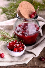 sauce of wild organic cranberries on a wooden table with berries