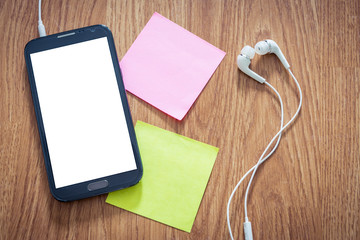 Closeup of black smartphone with white screen with headphones, s