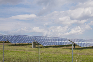 Solar panels on green grass with blue sky