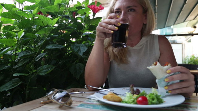 Woman eating  salad and meat in  restaurant