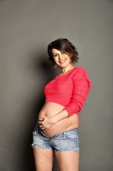 Beautiful pregnant woman on gray background