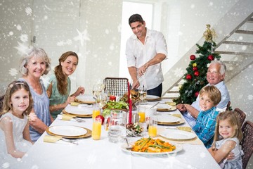 Composite image of family having christmas meal at dining table