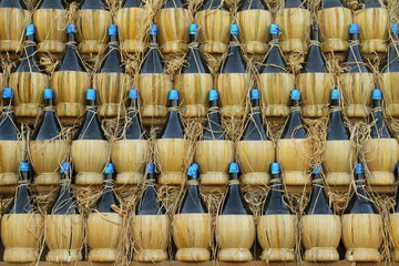 arranged many  chianti bottles in traditional pyramid on cart - obrazy, fototapety, plakaty
