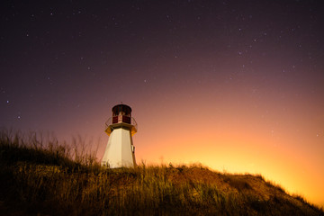 Naklejka na ściany i meble lighthouse with night sky at background stars trails