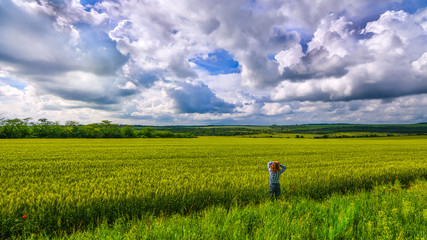 Alone girl viewing in wheat field with clouds stormy skies - 70725934